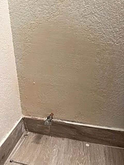 Finished textured wall repair beside a plumbing connection