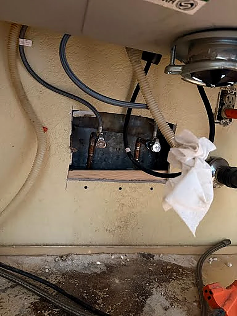 Under-sink plumbing repair in progress